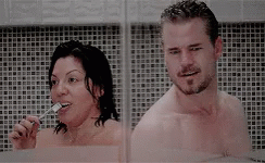 Man and Woman Brushing Teeth in Shower Together
