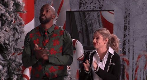 Man And Woman Clapping In Front Of Candy Cane Display GIF
