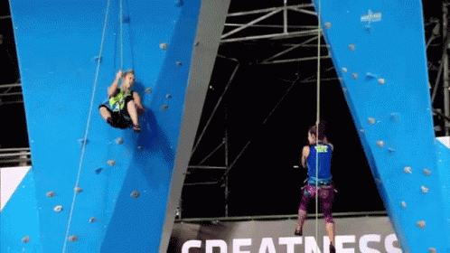 Man And Woman Climbing Blue Wall With Greatness Background GIF