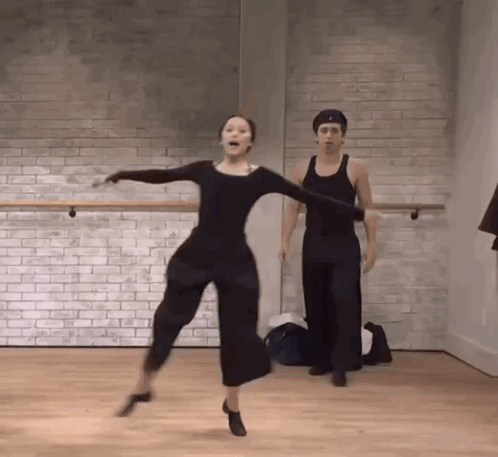 Man And Woman Dancing Against Brick Wall GIF