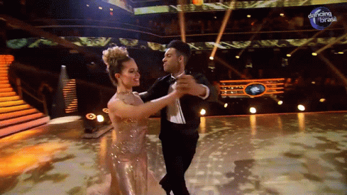 Man And Woman Dancing In Front Of Dancing Brasil Sign GIF