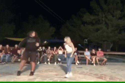 Man and Woman Dancing in Front of Group
