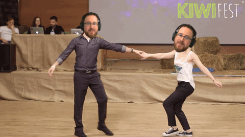 Man and Woman Dancing in Front of Kiwifest Sign