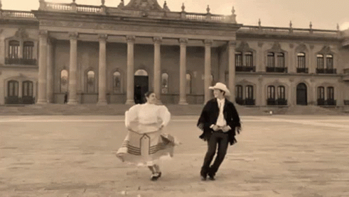 Man and Woman Dancing in Front of Large Building