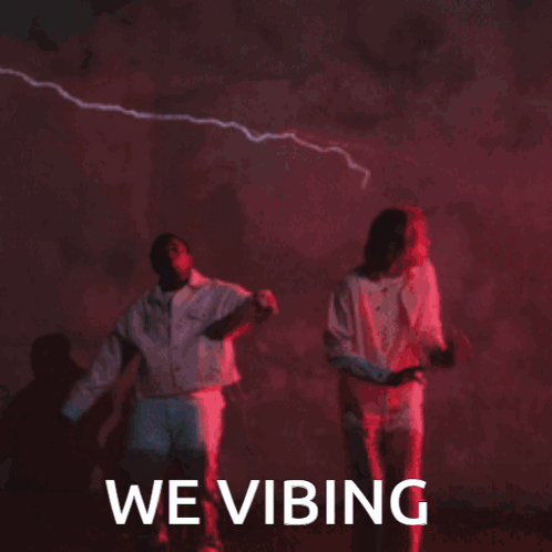 Man and Woman Dancing in Front of We Vibing Sign