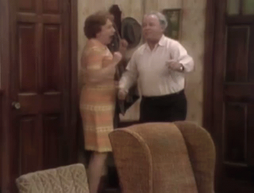 Man and Woman Dancing in Living Room With Chairs