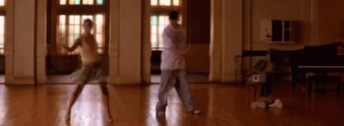 Man and Woman Dancing in Room With Piano