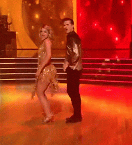 Man and Woman Dancing on Red-Lit Stage