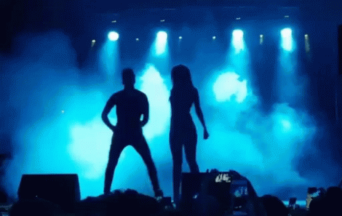 Man and Woman Dancing on Stage Before Crowd