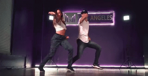 Man and Woman Dancing on Stage in Front of Sessions Sign