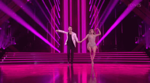 Man And Woman Dancing On Stage With Purple Light GIF