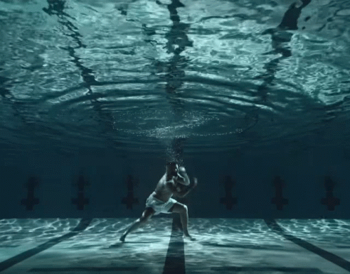 Man and Woman Dancing Underwater With Letter T