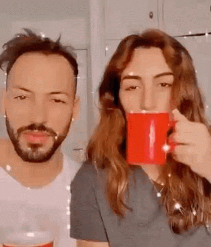 Man And Woman Drinking Coffee From Red Mugs GIF