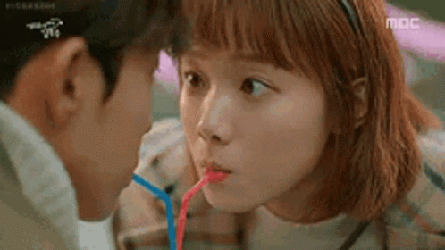 Man And Woman Drinking Through Straws GIF