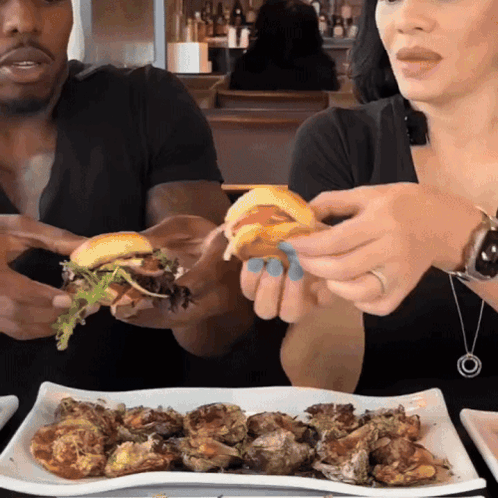 Man and Woman Eating Hamburgers and Oysters