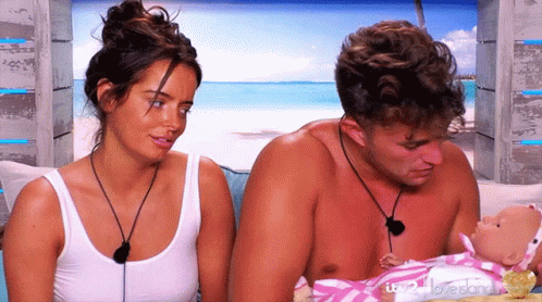 Man and Woman Holding Baby Doll Saying Love Island