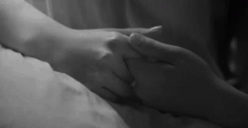 Man and Woman Holding Hands on Bed