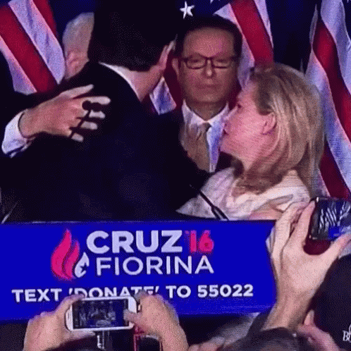Man And Woman Hugging In Front Of Cruz 16 Fiorina Sign GIF