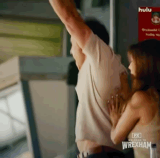 Man And Woman Hugging In Front Of Wrexham Sign GIF