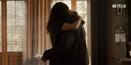 Man And Woman Hugging In Room With Netflix Logo GIF