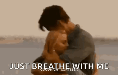 Man And Woman Hugging On Beach Saying Just Breathe With Me GIF