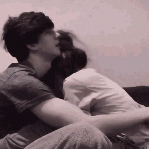 Man And Woman Hugging On Couch In Black And White GIF