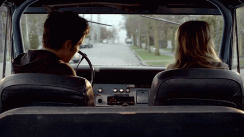 Man and Woman in Back Seat of Car Looking Out Window