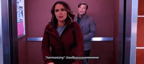 Man and Woman in Elevator Woman Saying Harmonizing