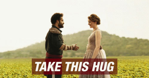 Man and Woman in Field Saying Take This Hug