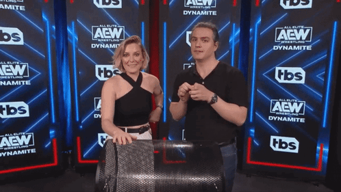 Man and Woman in Front of AEW Wall