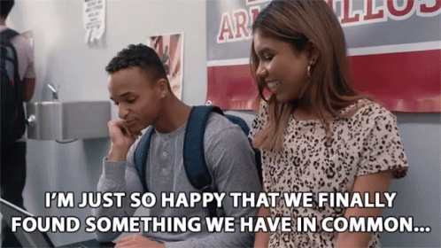 Man And Woman In Front Of Art Sign GIF