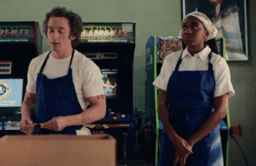 Man And Woman In Front Of Reaper Arcade GIF
