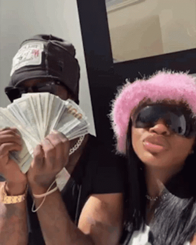 Man and Woman in Pink Hat Holding Money