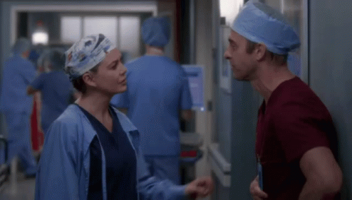 Man and Woman in Scrubs Talking