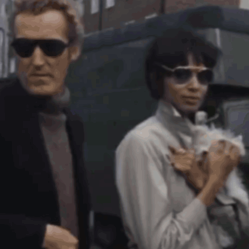 Man and Woman in Sunglasses Holding White Dog