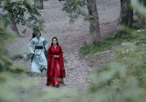 Man and Woman in Traditional Costume Walking Through Forest