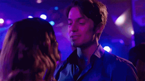 Man and Woman Kissing in Club With Purple Lights