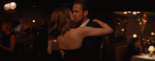 Man And Woman Kissing In Front Of Bar GIF