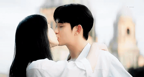 Man And Woman Kissing In Front Of Building GIF