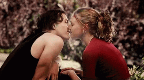 Man And Woman Kissing In Front Of Bush GIF