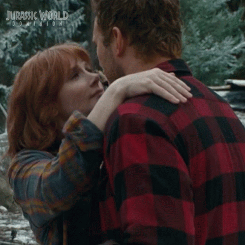 Man and Woman Kissing in Front of Jurassic World Dominion Poster