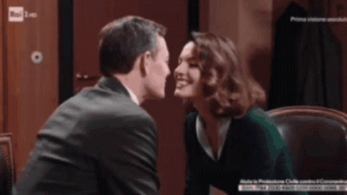 Man And Woman Kissing In Front Of Rai Sign GIF