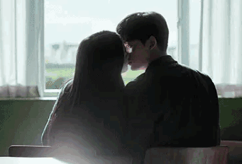 Man and Woman Kissing in Front of Window