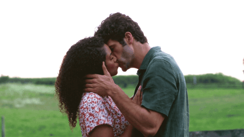 Man And Woman Kissing In Green Field GIF