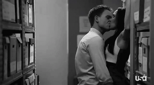 Man and Woman Kissing in Library