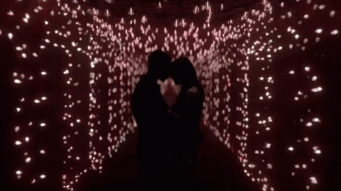 Man And Woman Kissing In Room With Lots Of Lights GIF