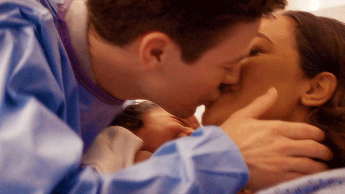 Man And Woman Kissing While Holding Baby GIF