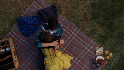 Man and Woman Laying on Blanket