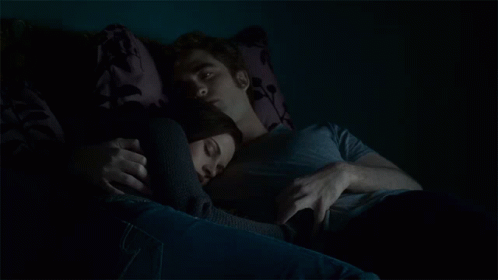 Man and Woman Laying on Couch in Dark