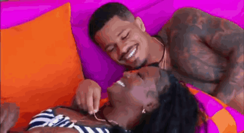 Man and Woman Laying on Couch Man Putting Something on Womans Neck